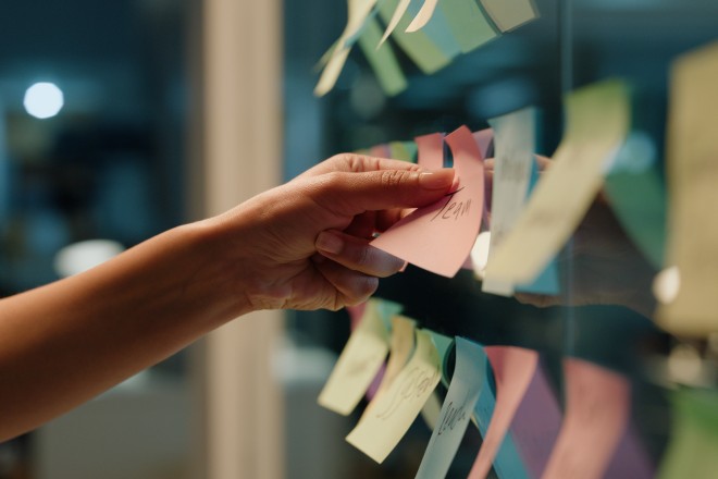 Hand planning for business with sticky notes on a glass wall