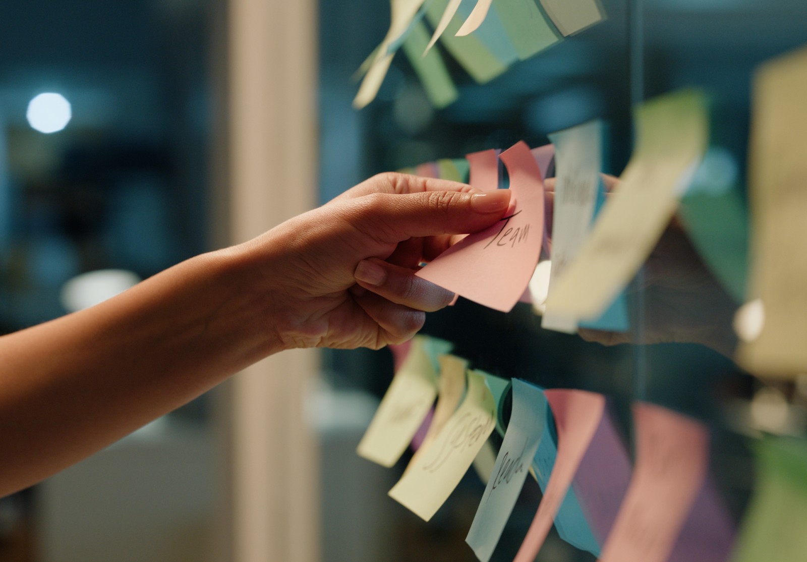 Hand planning for business with sticky notes on a glass wall