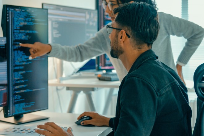 Tech team professionals collaborate discuss software development strategies in modern office. Software developer, artificial intelligence and programming.